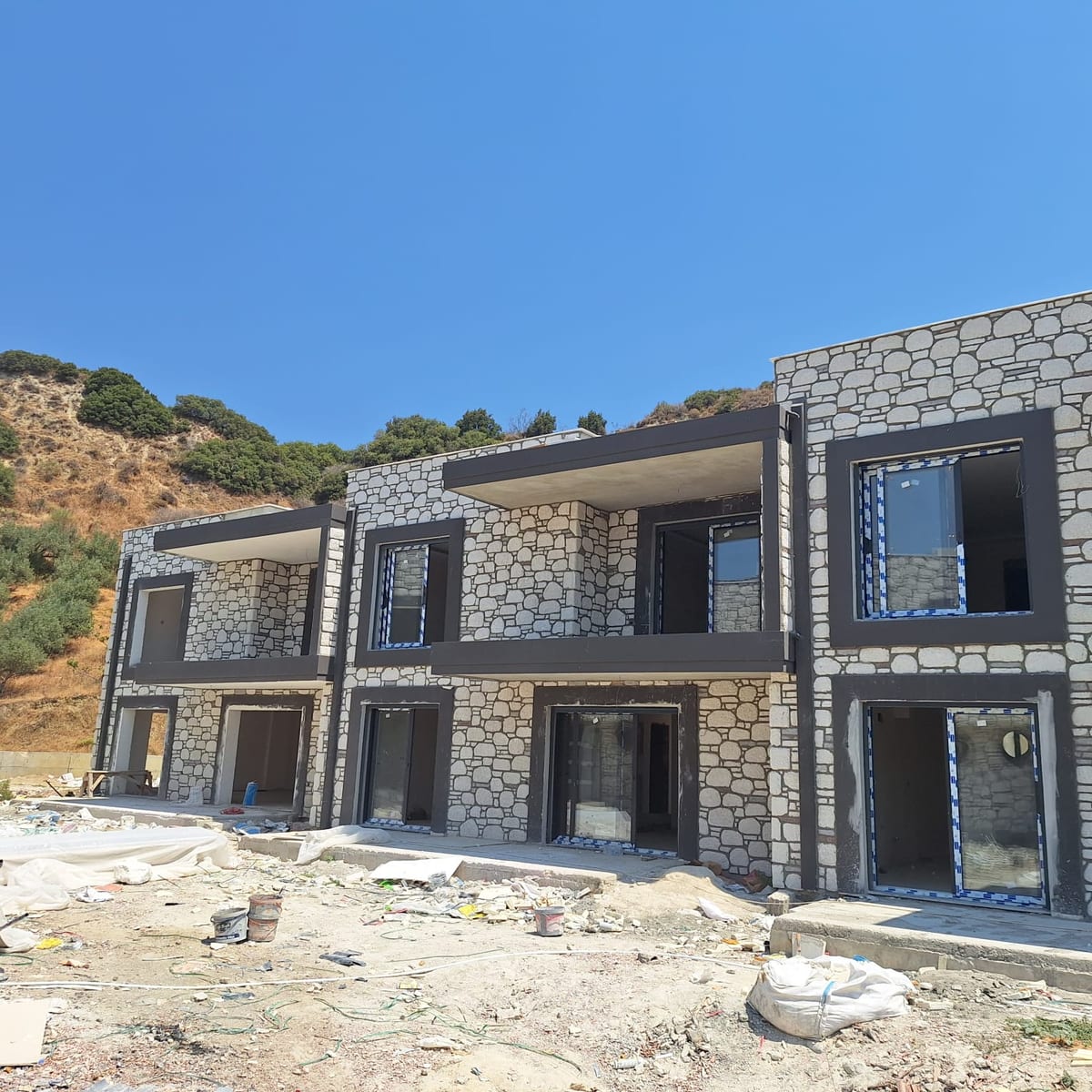 Yamaçta sıra konutlar gri kültür taşı cephe